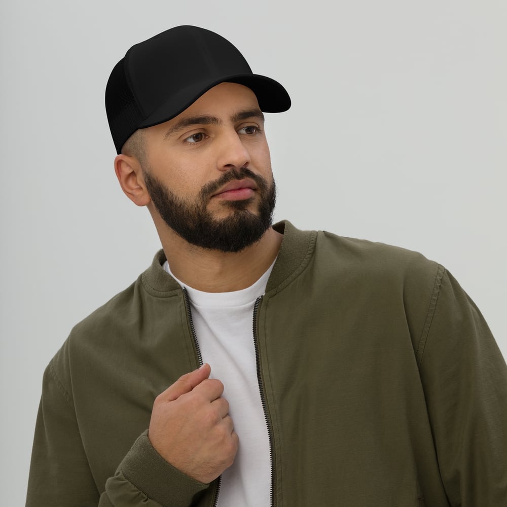 Man wearing custom trucker hat in urban studio setting, personalized logo cap for branding