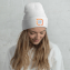 Female model wearing embroidered custom beanie with a custom logo design embroidered on the front