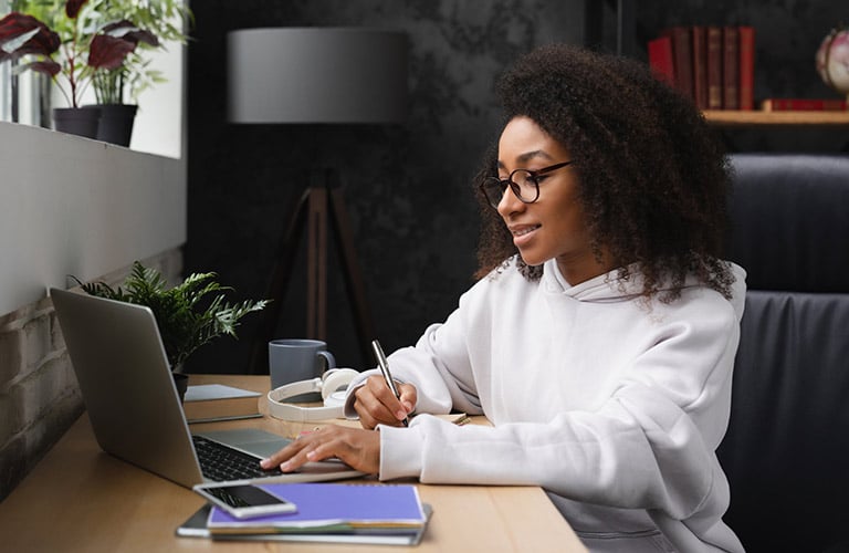 woman using laptop studying business ideas for school project